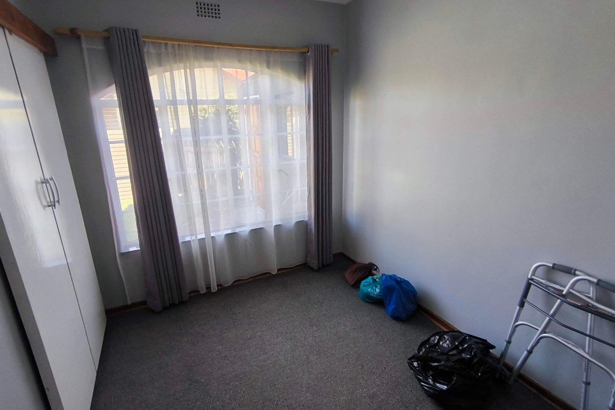 A bedroom featuring neutral wall paint, carpeted flooring, and a built-in wardrobe, offering a functional and well-lit living space.