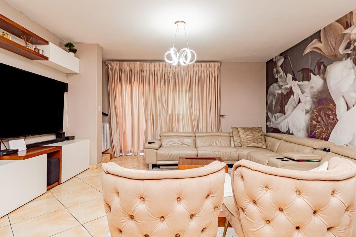 A comfortable living room featuring tiled flooring, built-in shelving, and a sliding glass door that provides access to the outdoor area.