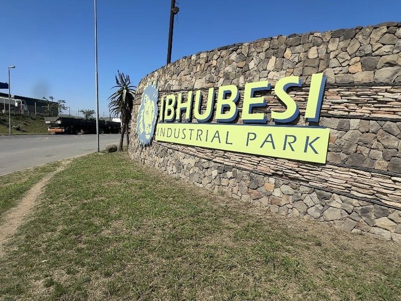 Street view of the entrance to Bhubesi Industrial Park, featuring a prominent stone-clad boundary wall and clear signage.