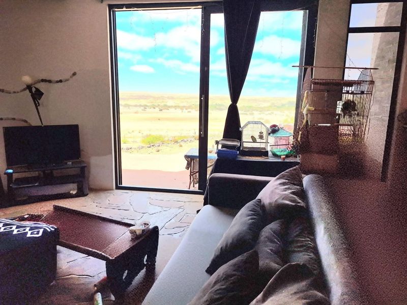 Living room featuring large sliding glass doors that provide natural light and expansive views of the surrounding landscape.
