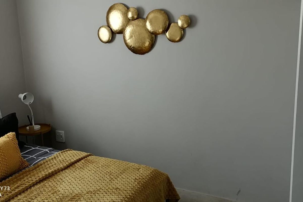 A neutrally painted bedroom featuring a clean wall finish and a standard electrical outlet.