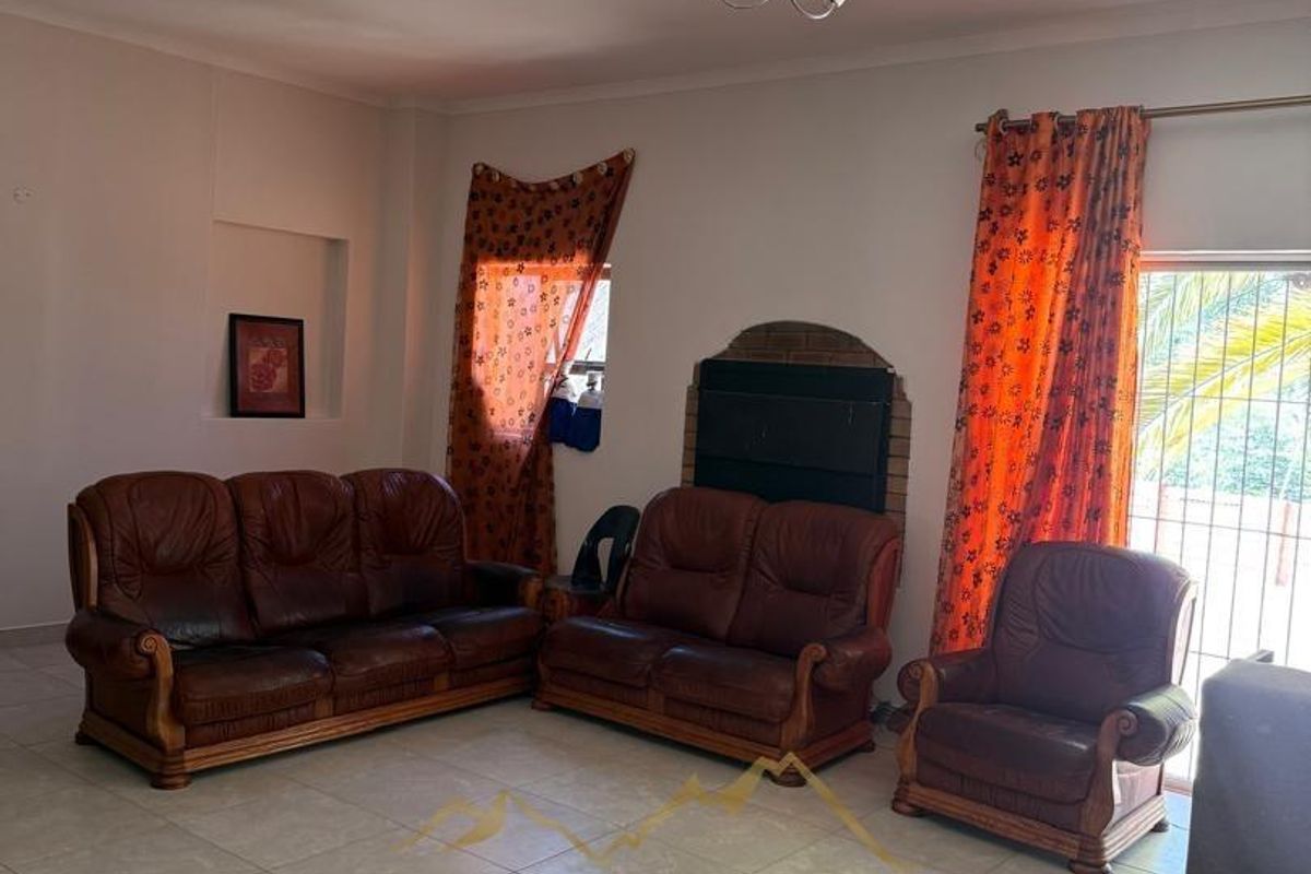 Spacious living room featuring tiled flooring, a built-in fireplace, and direct access to the outdoor area through a sliding glass door.