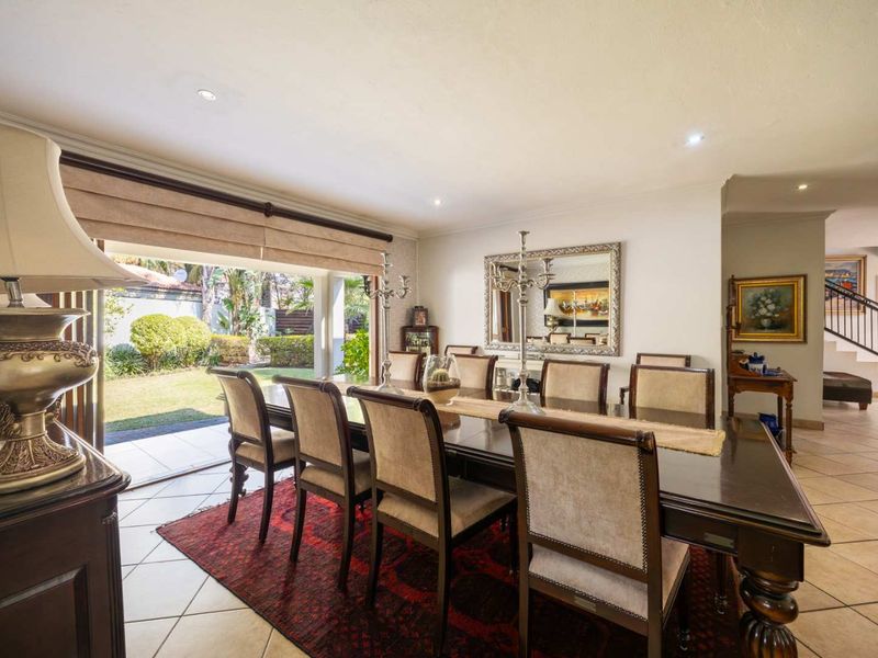 Spacious dining room featuring ceramic floor tiles, recessed lighting, and large sliding glass doors providing seamless access to the rear garden.