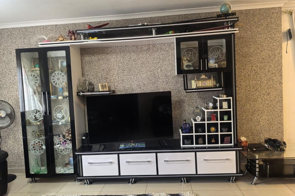 A living room area featuring large format floor tiles and a prominent textured feature wall.