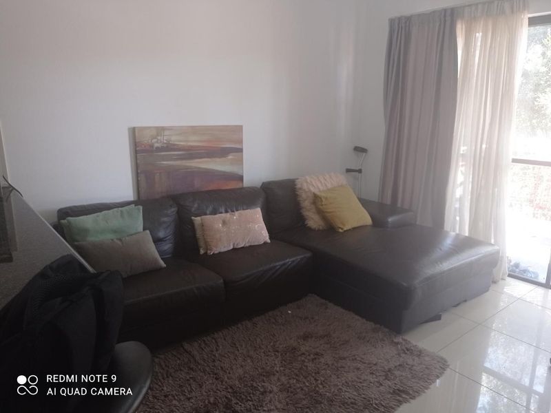 A living room area featuring tiled flooring and a sliding glass door providing access to an outdoor space.
