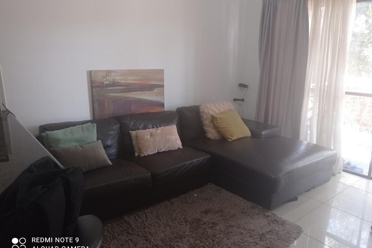 A living room area featuring tiled flooring and a sliding glass door providing access to an outdoor space.