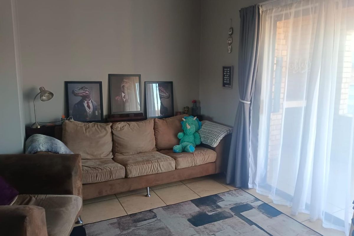 A living room area featuring tiled flooring and a sliding glass door providing access to the exterior.