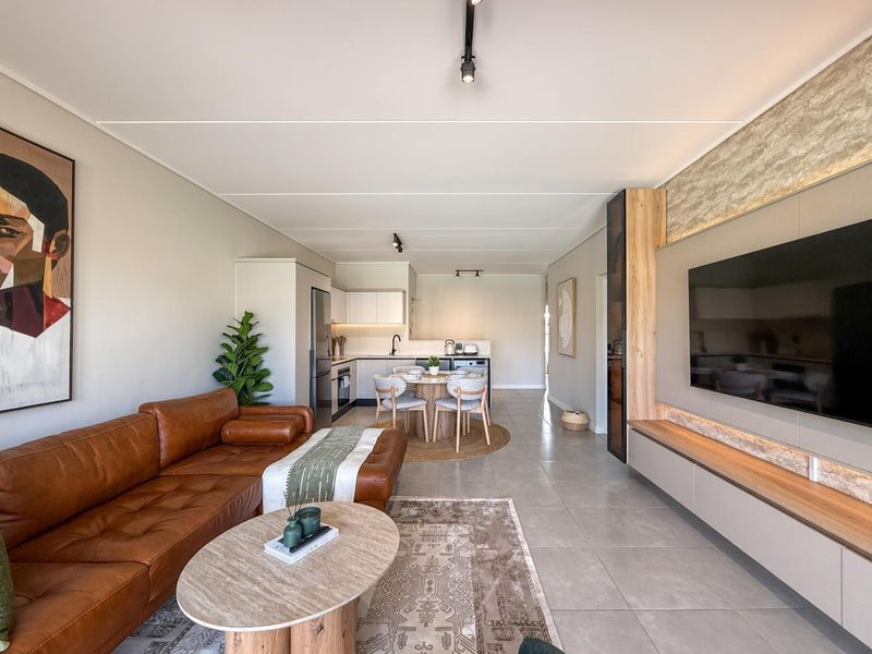 Modern open-plan living area featuring a sleek kitchen, tiled floors, and a custom built-in media wall with integrated lighting.