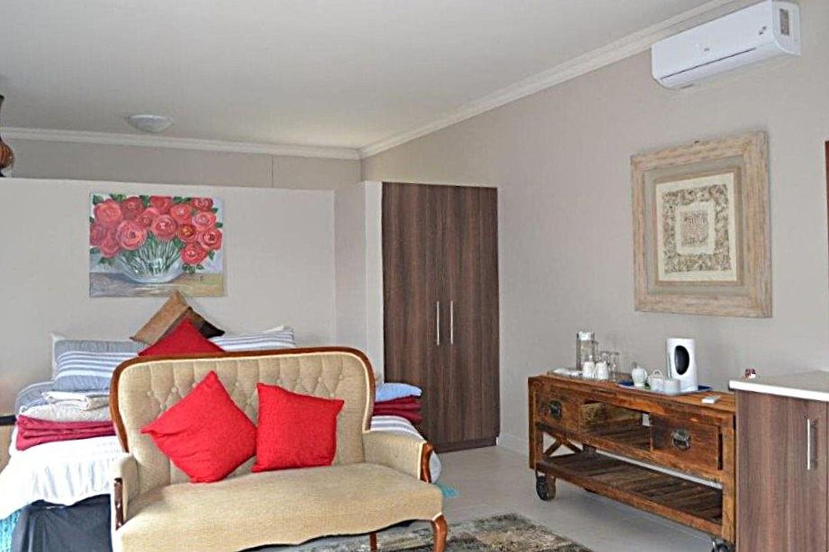 A well-maintained bedroom featuring a built-in wardrobe, split-system air conditioning, and neutral wall finishes.