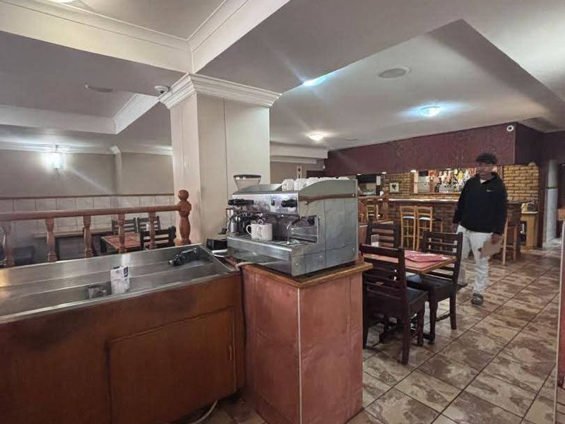 Open plan commercial dining and bar area featuring tiled flooring, built-in service counters, and recessed ceiling lighting.