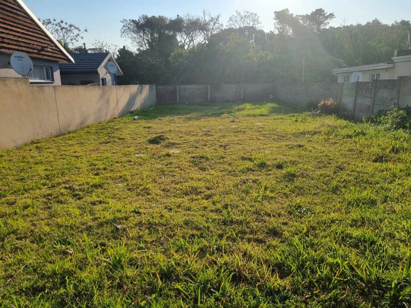 A spacious, level backyard area enclosed by precast concrete boundary walls, offering potential for landscaping or outdoor development.