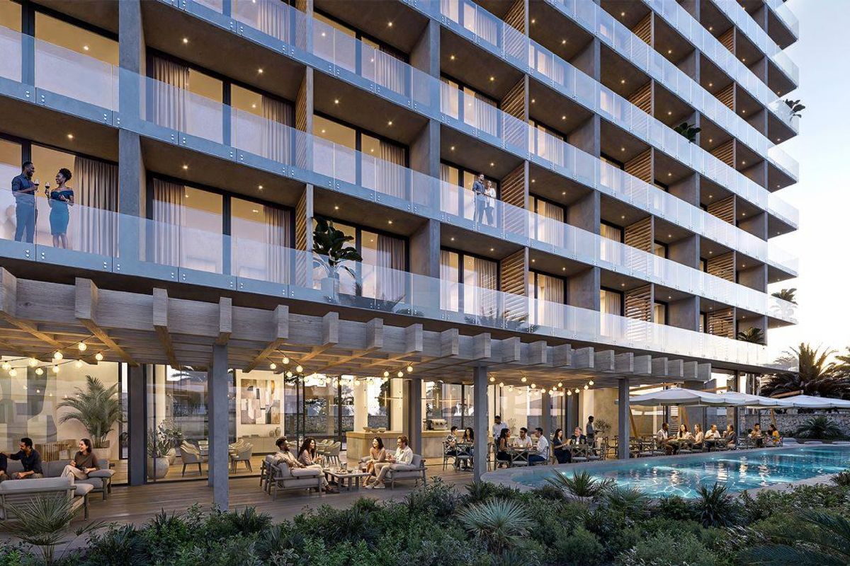 A modern apartment complex exterior featuring a swimming pool, covered patio area, and glass-railed balconies, showcasing contemporary architectural design and outdoor living spaces.