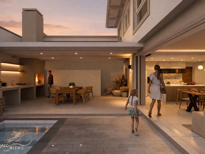 A modern open-plan living space featuring a seamless transition between the indoor kitchen and the covered outdoor patio with a built-in braai and pool.