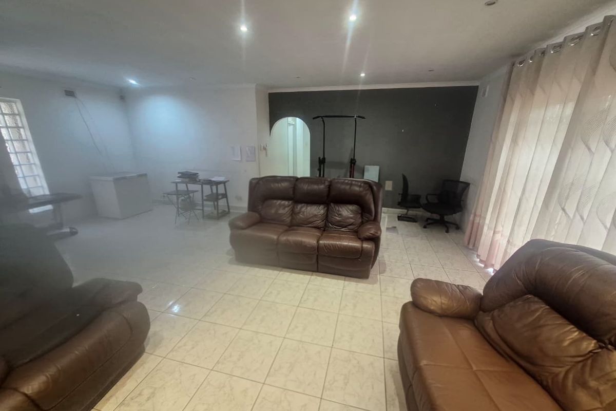 Spacious living area featuring tiled flooring, recessed downlighting, and an arched entryway, offering a versatile layout for comfortable family living.