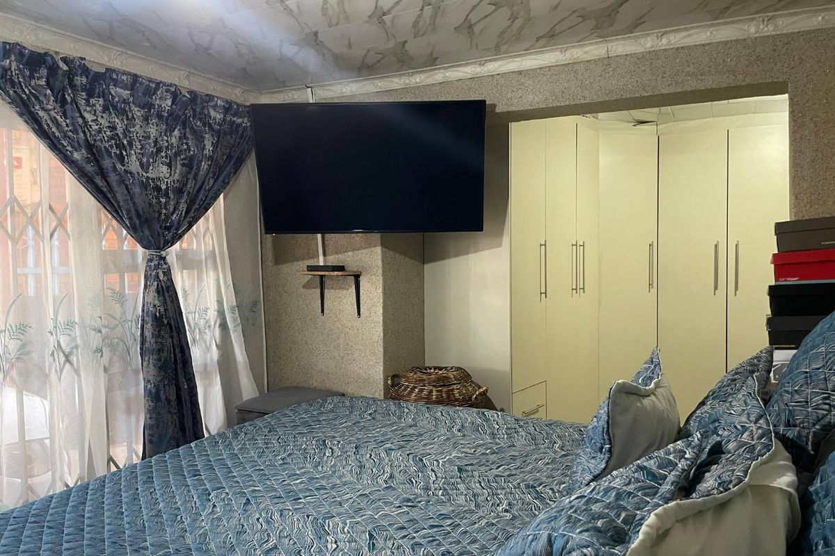 Bedroom featuring built-in cupboards and decorative ceiling finishes, providing functional storage space within the room.