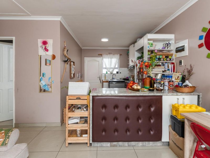 Open plan living area featuring a kitchen with granite countertops and tiled flooring, providing a functional space for cooking and daily living.