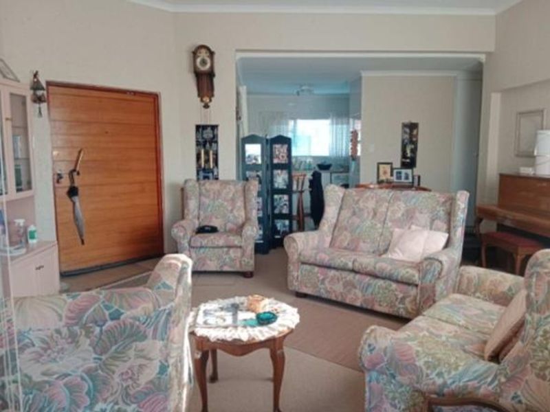 Open plan living area featuring a timber front door and neutral wall finishes, providing a functional space with potential for modern updates.