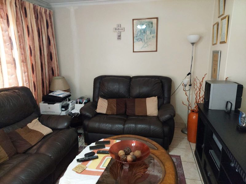 A living room featuring tiled flooring and coved ceiling details, providing a functional space for relaxation.
