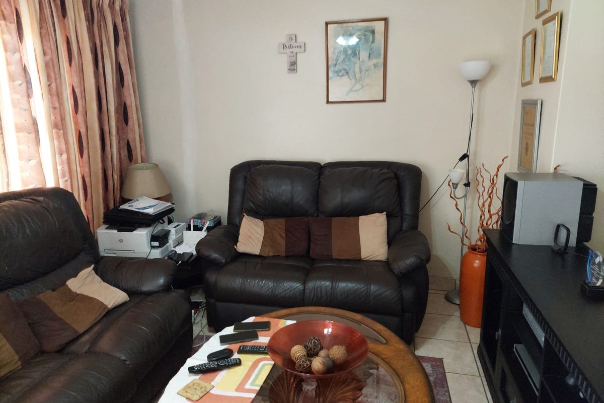A living room featuring tiled flooring and coved ceiling details, providing a functional space for relaxation.