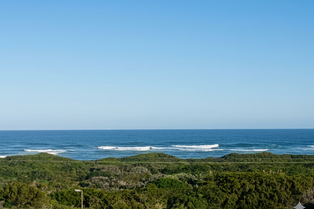 A scenic elevated view overlooking lush coastal vegetation and the ocean horizon.