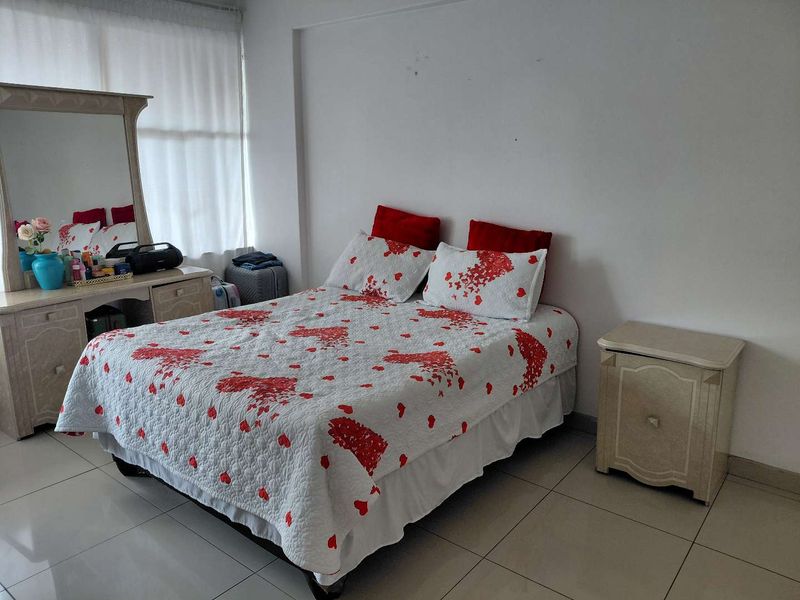 A functional bedroom featuring tiled flooring and neutral wall finishes, providing a blank canvas for potential interior design updates.