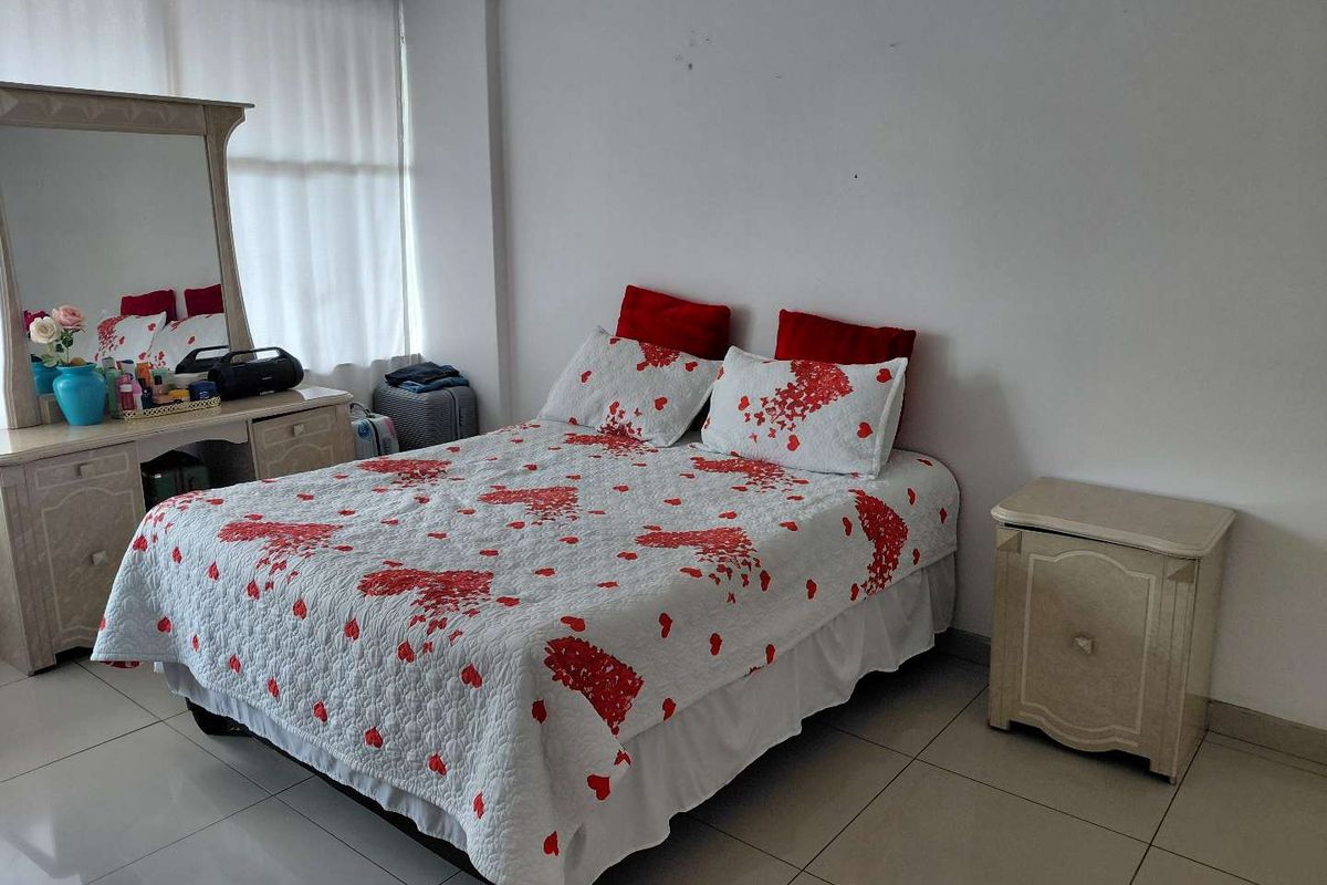 A functional bedroom featuring tiled flooring and neutral wall finishes, providing a blank canvas for potential interior design updates.