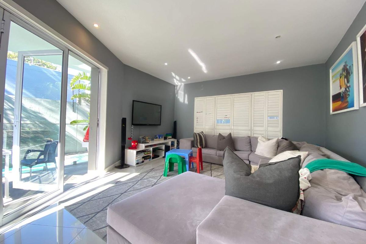 Spacious living room featuring large sliding glass doors that provide seamless access to the outdoor pool area and abundant natural light.