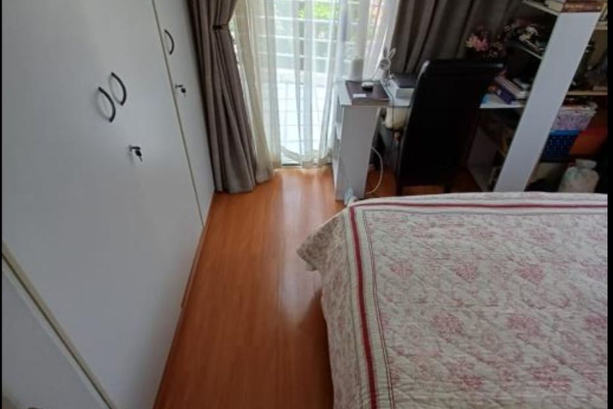 A bedroom featuring laminate flooring and built-in cupboards, with a sliding door providing access to an outdoor area.