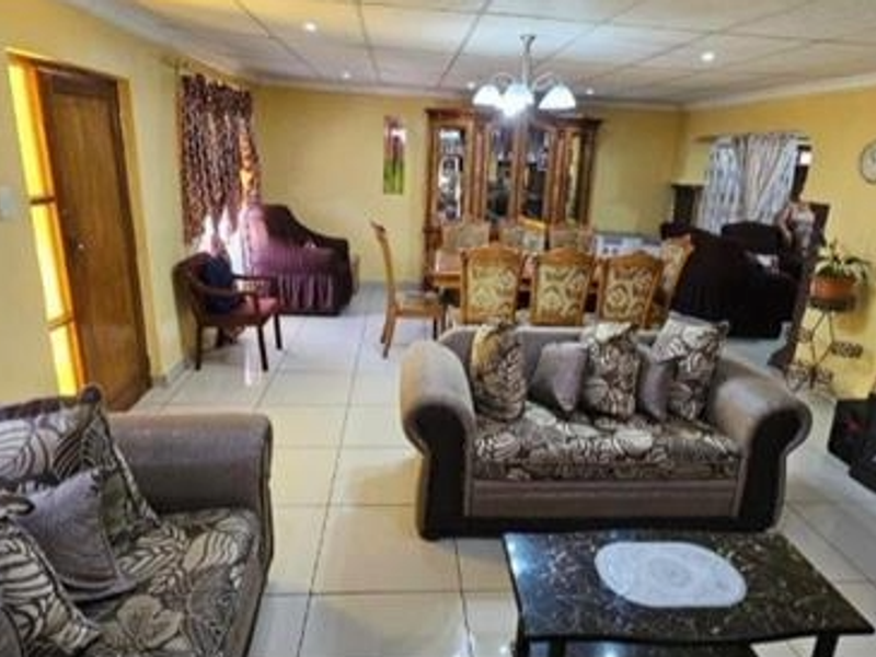 Spacious open-plan living and dining area featuring tiled flooring and recessed ceiling lighting, providing a versatile layout for family living and entertaining.