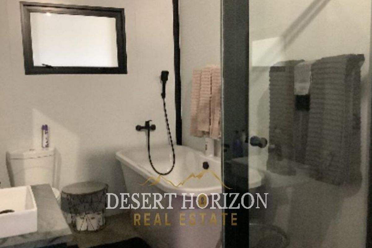 A modern bathroom featuring a freestanding bathtub, a separate glass-enclosed shower, and a contemporary vanity unit with a basin.