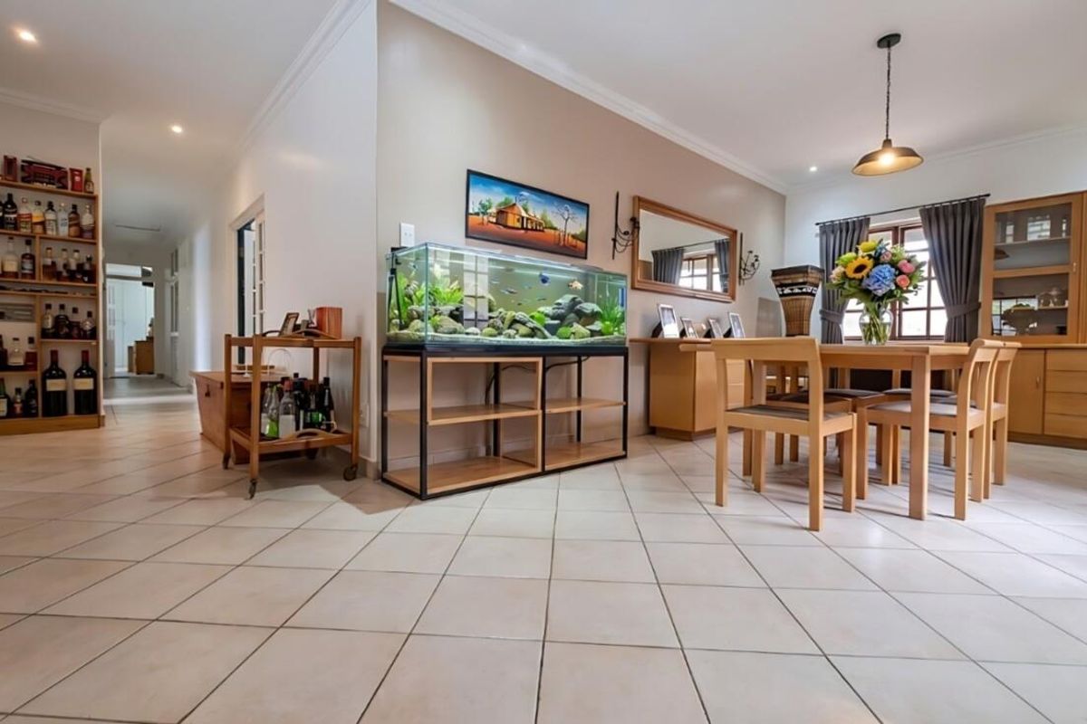 A well-maintained dining area featuring neutral tiled flooring, recessed lighting, and built-in shelving, creating a functional and inviting space for meals.