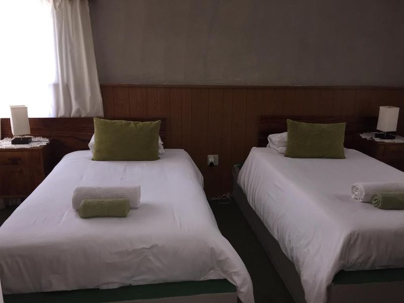 A bedroom featuring wood paneling on the wall and a standard electrical outlet.