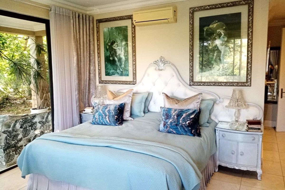 Spacious bedroom featuring tiled flooring, a wall-mounted air conditioning unit, and large sliding glass doors providing direct access to the outdoor area.
