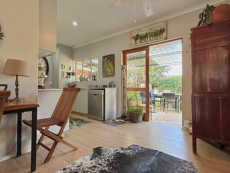 Open plan kitchen and living area featuring light tiled flooring and a sliding glass door providing direct access to the outdoor patio.