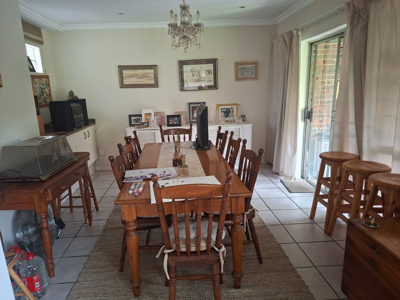 A dining room featuring ceramic floor tiles, crown molding, recessed lighting, and a sliding glass door providing access to the exterior.