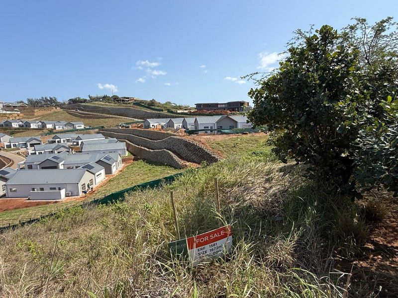 An elevated view of a residential development site featuring terraced retaining walls and surrounding landscape, showcasing the available vacant land.