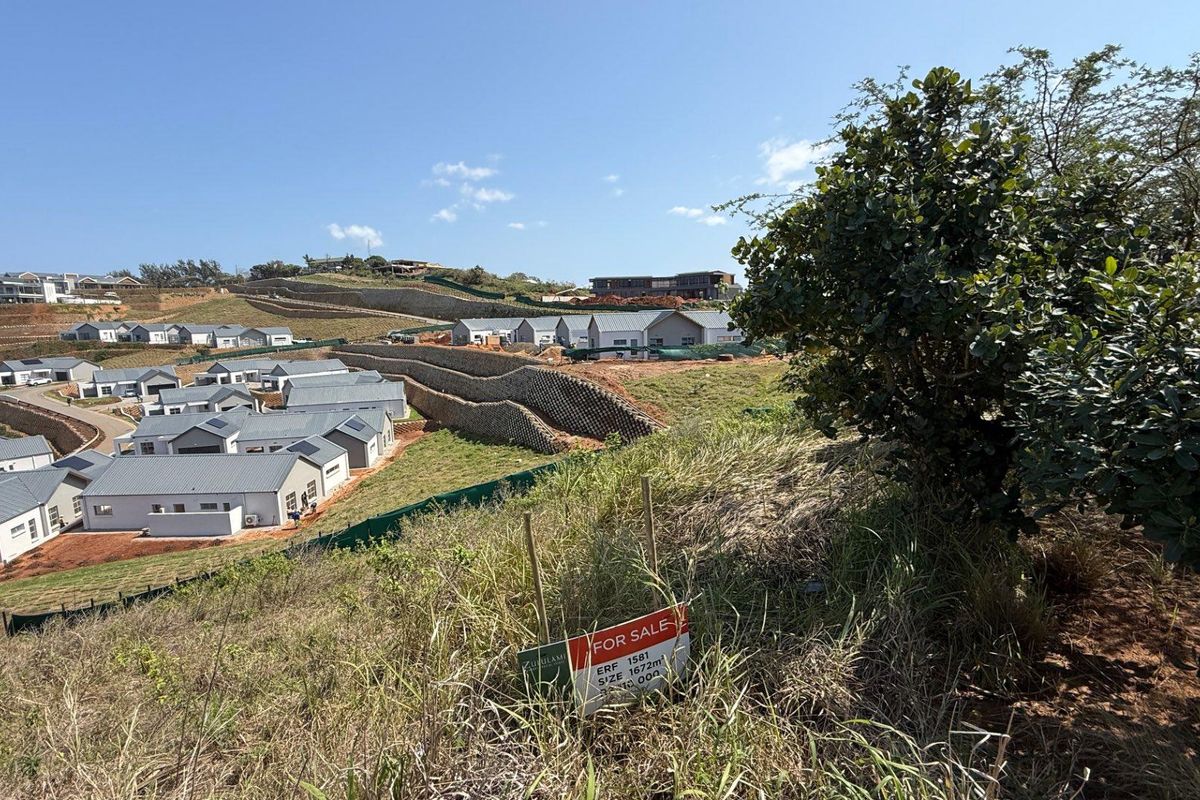 An elevated view of a residential development site featuring terraced retaining walls and surrounding landscape, showcasing the available vacant land.