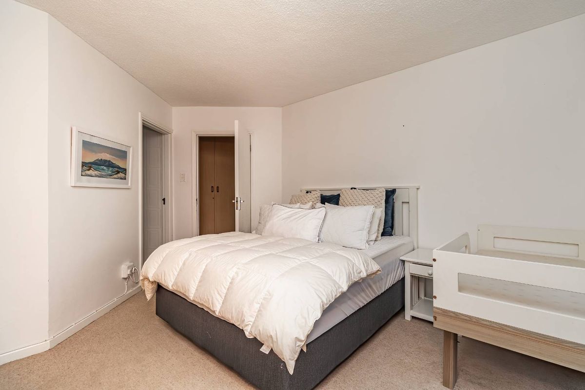 A functional bedroom featuring neutral wall finishes, carpeted flooring, and built-in closet storage.