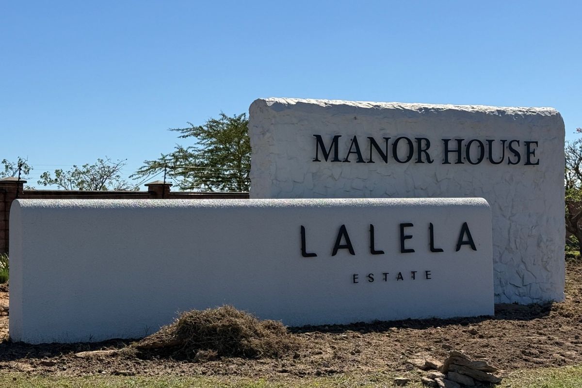 A clear view of the Lalela Estate Manor House entrance signage and surrounding boundary wall.