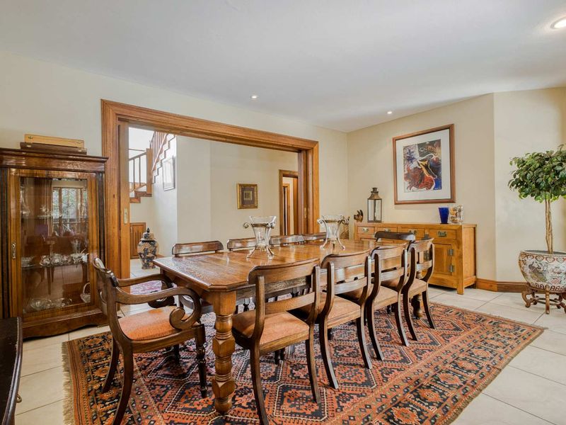 Spacious dining room featuring tiled flooring, recessed lighting, and a large timber-framed opening leading to the staircase.