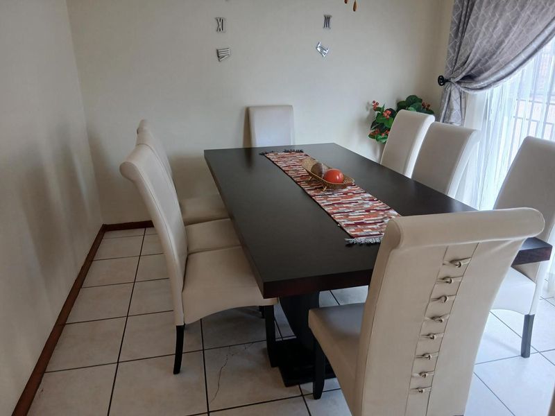 A dining room featuring ceramic tiled flooring and a sliding glass door providing access to the exterior.