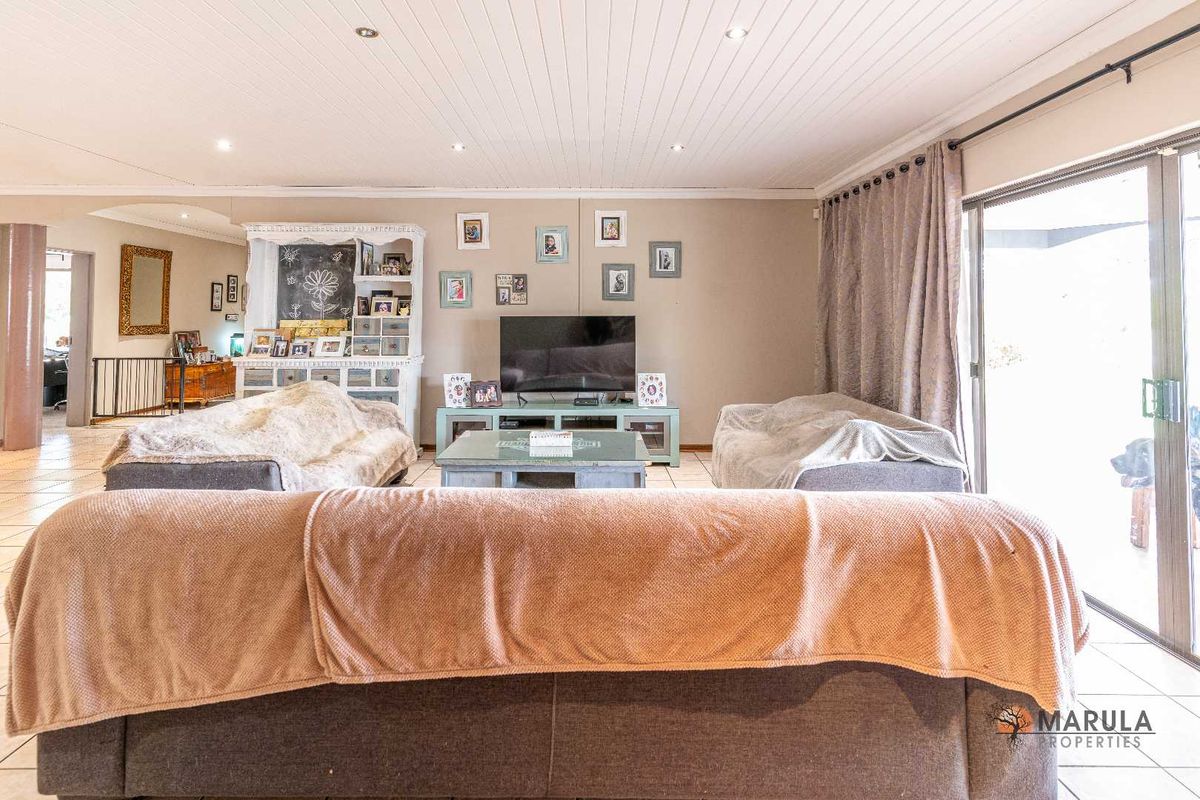Spacious living room featuring tiled flooring, recessed ceiling lighting, and large sliding glass doors providing access to the outdoor area.