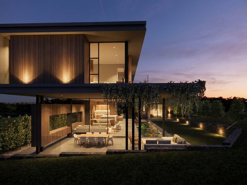 A modern architectural residence featuring a cantilevered upper level, timber cladding, and a seamless transition to a covered patio and landscaped rear garden.