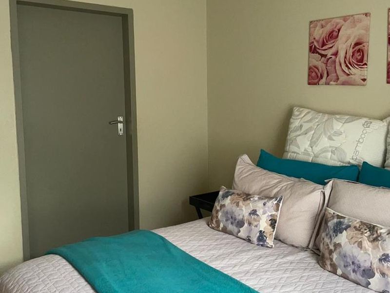 A neutrally painted bedroom featuring coving and a built-in air vent, providing a clean and functional space.