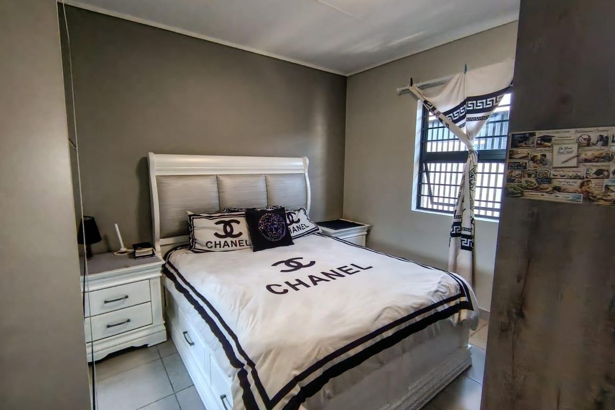 A functional bedroom featuring tiled flooring and a window fitted with security bars, offering a neutral base for personalization.