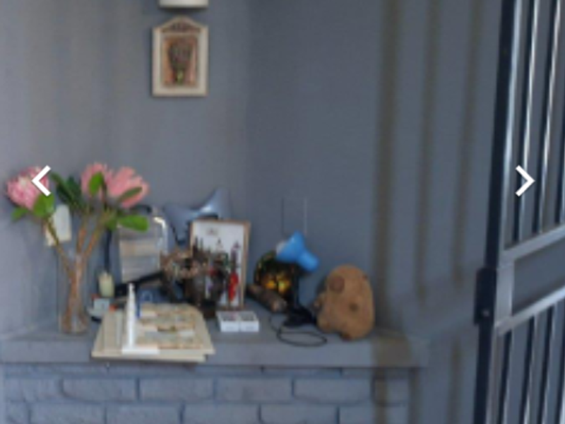 A corner area featuring a brick masonry base, wall lighting, and a security gate, captured in a low-quality, blurry image.