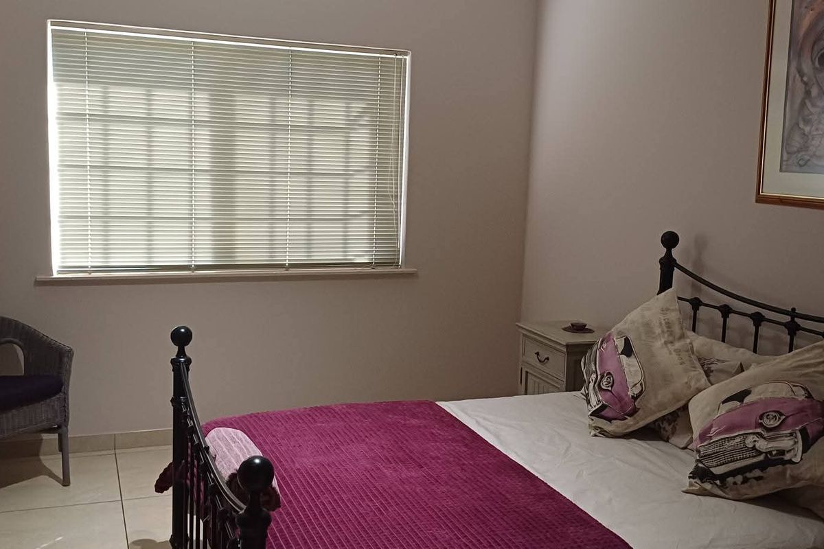 A well-lit bedroom featuring tiled flooring and a window with fitted blinds, providing a comfortable and functional living space.