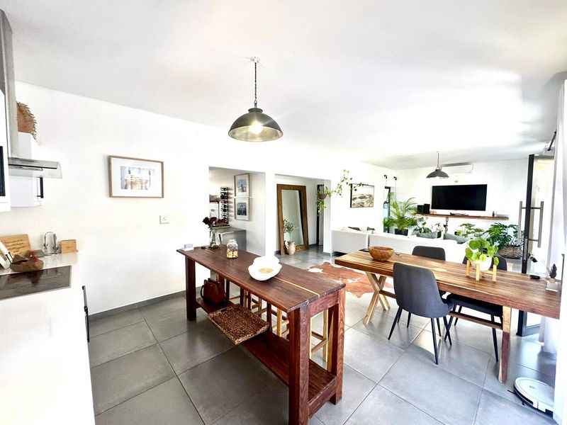 Spacious open-plan living area featuring modern kitchen cabinetry, tiled flooring, and integrated dining space, creating a bright and functional layout for daily living.