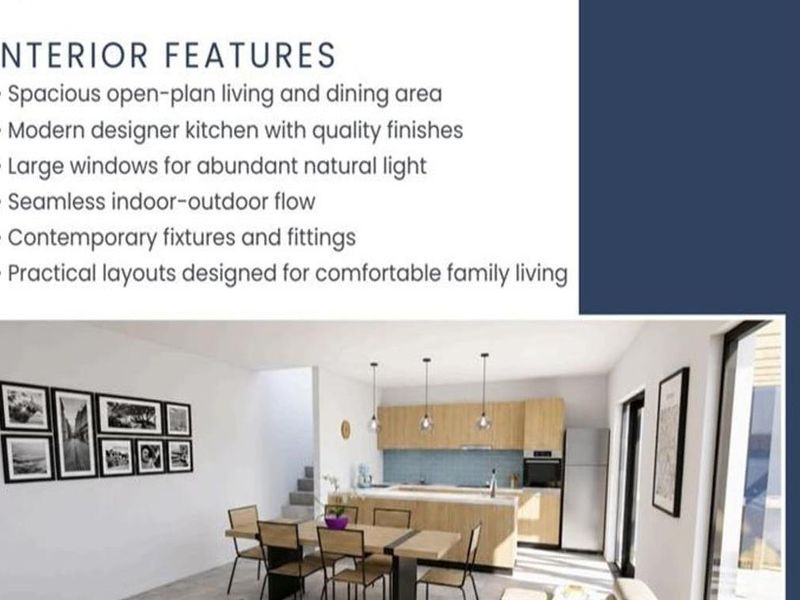 An open-plan living and dining area featuring a modern kitchen with light wood cabinetry, pendant lighting, and a tiled splashback.