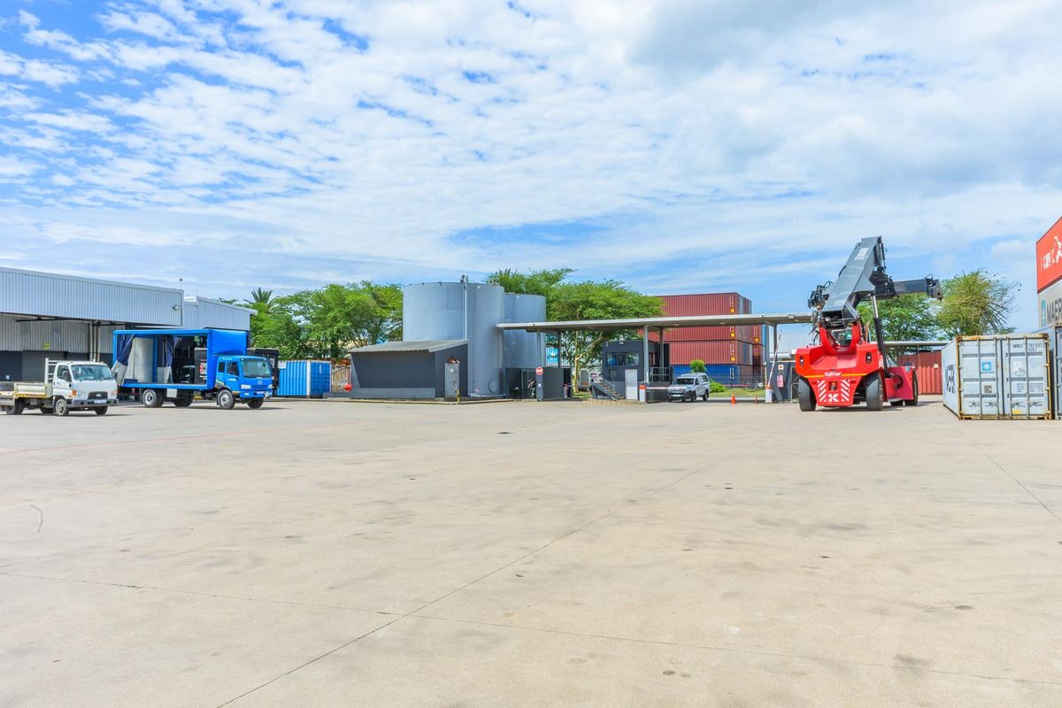 Expansive industrial yard featuring large storage tanks, covered loading areas, and heavy-duty operational infrastructure for logistics and transport activities.